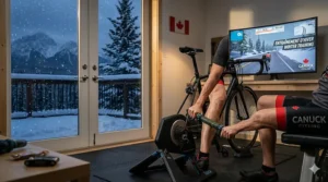 An indoor cyclist using a muscle roller stick next to a trainer during a Canadian winter workout.