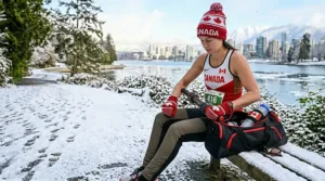 A compact muscle roller stick tucked into a gym bag next to a Canadian flag water bottle.