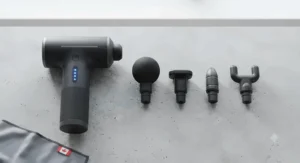 Flat lay showing four interchangeable massage heads and LED speed indicator lights of a low-cost percussion massager available under $50 CAD.