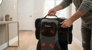 A portable shiatsu kneading massage cushion for chair being adjusted for travel or easy room-to-room carrying.